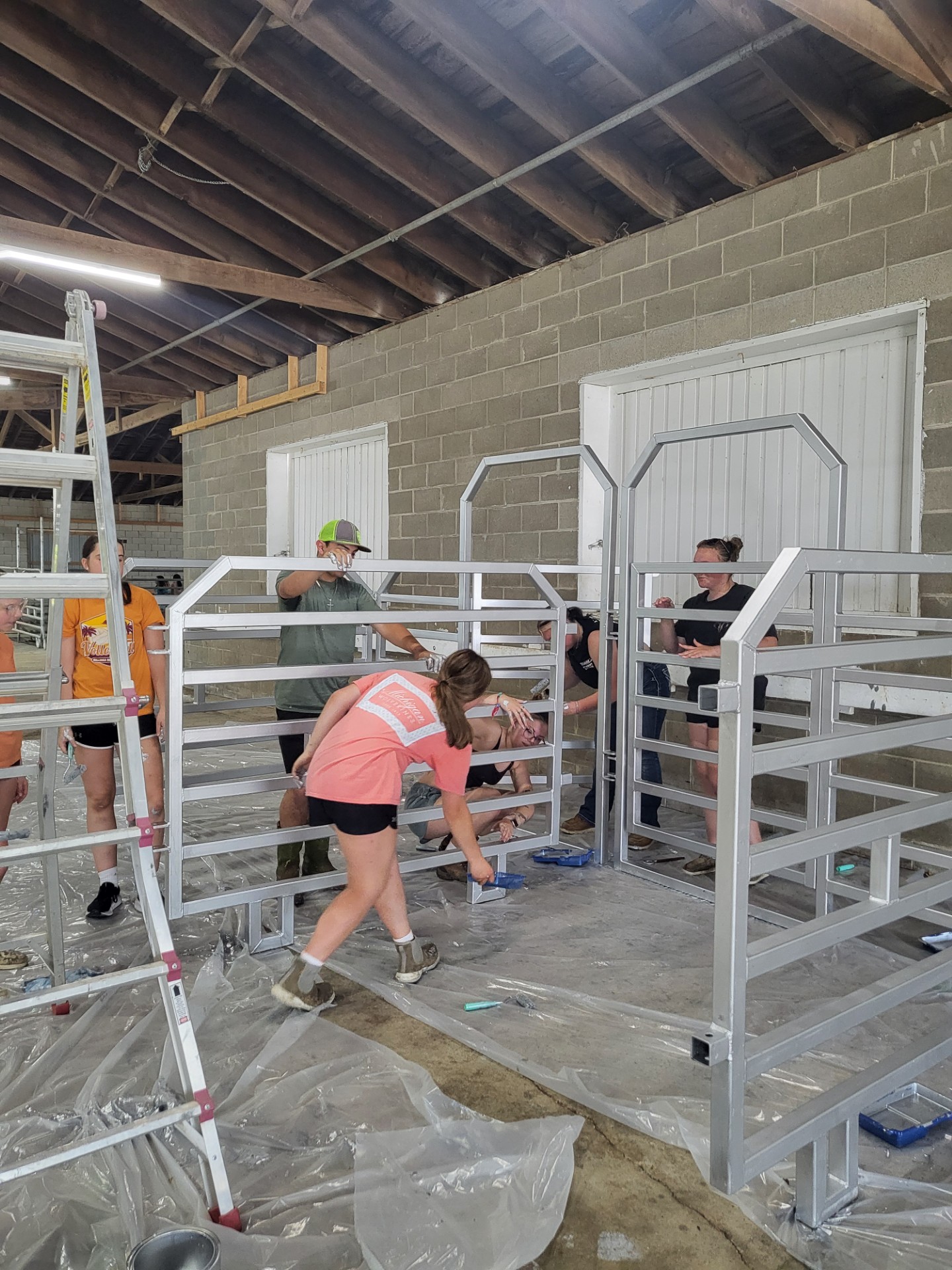 Teens helping to put up gates in a barn.